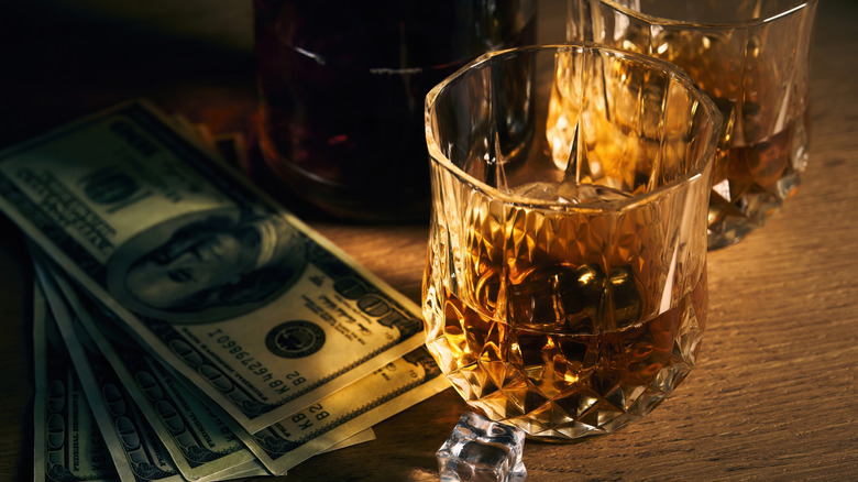 Glasses of bourbon with $100 bills