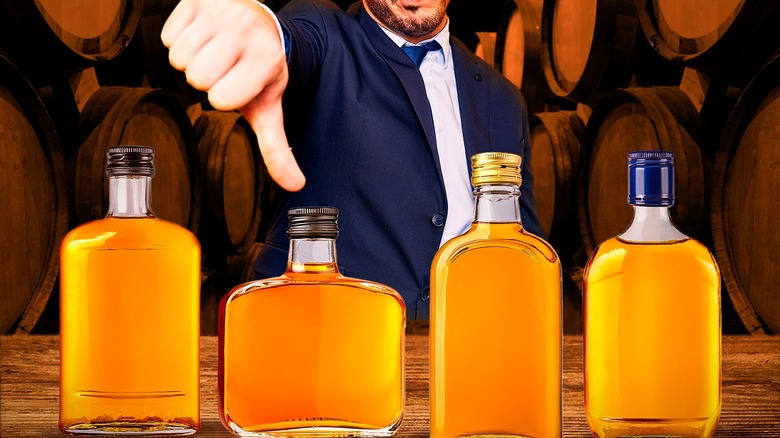 a thumbs down with bottles of bourbon