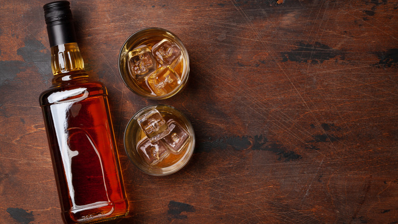 Generic whiskey bottle with glasses of whiskey on the rocks