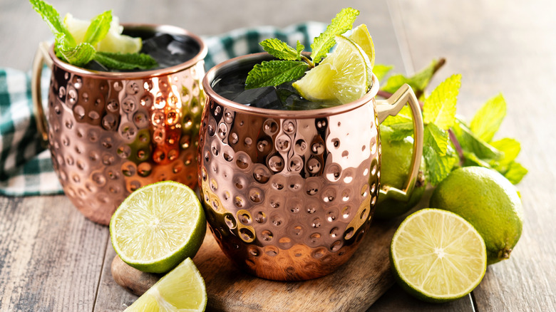 Moscow mule cocktails in copper mugs with fresh lime and mint sprig garnishes