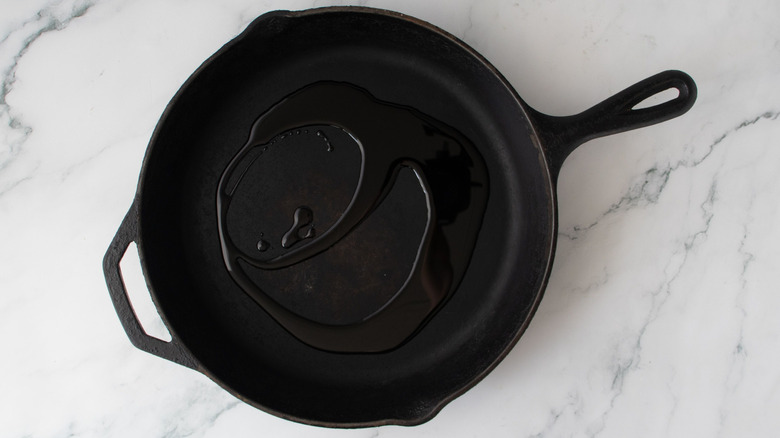 Olive oil drizzled in cast iron skillet