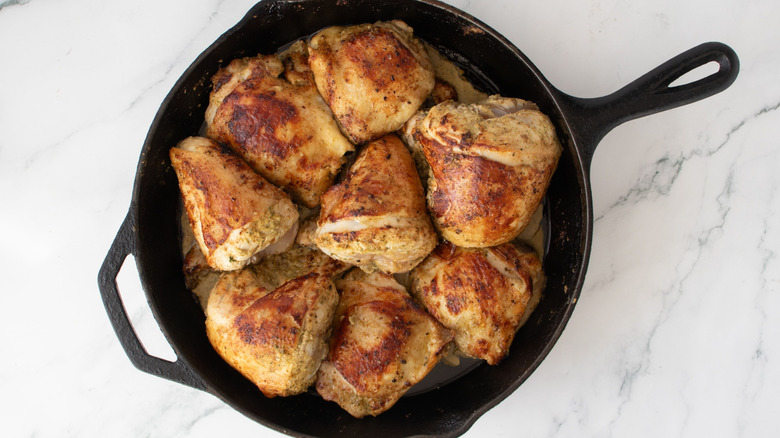 Seared chicken pieces in cast iron skillet