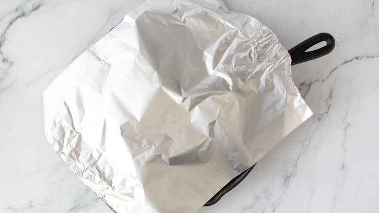 Piece of aluminum foil over skillet