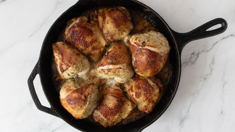 Seared chicken pieces in cast iron skillet