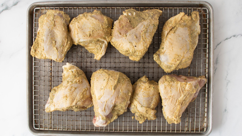 Marinated chicken pieces on wire rack