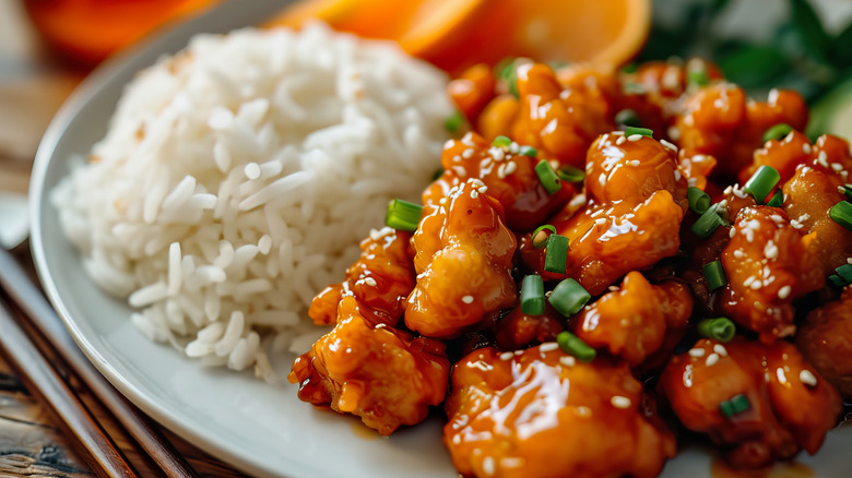 A plate with orange chicken and rice