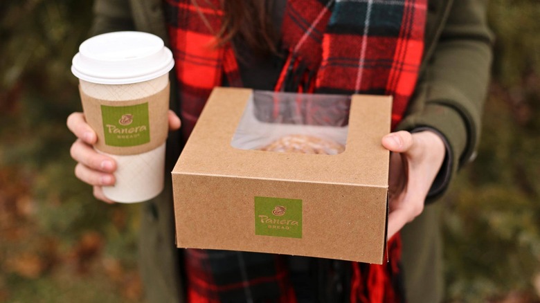 Person holding Panera to-go containers. 