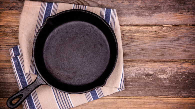 new cast iron pan pictured on towel