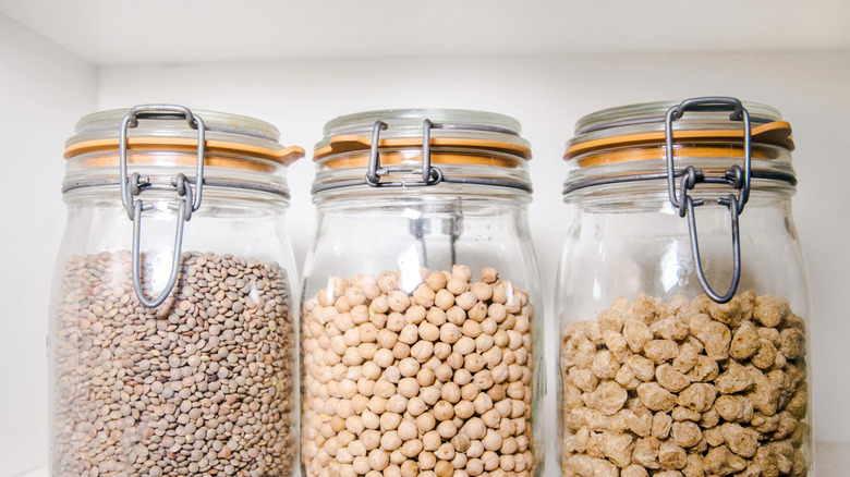 Glass jars filled with legumes inside a pantry