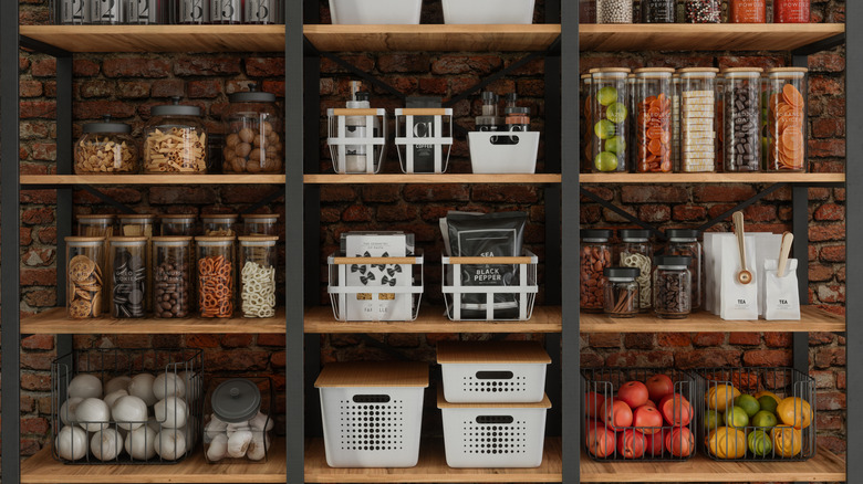 Organized, clean set of pantry shelves with fresh produce and clear containers of dry foods.