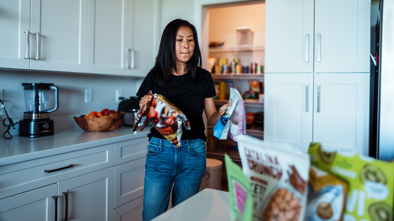 Person reorganizing and cleaning food from their pantry.