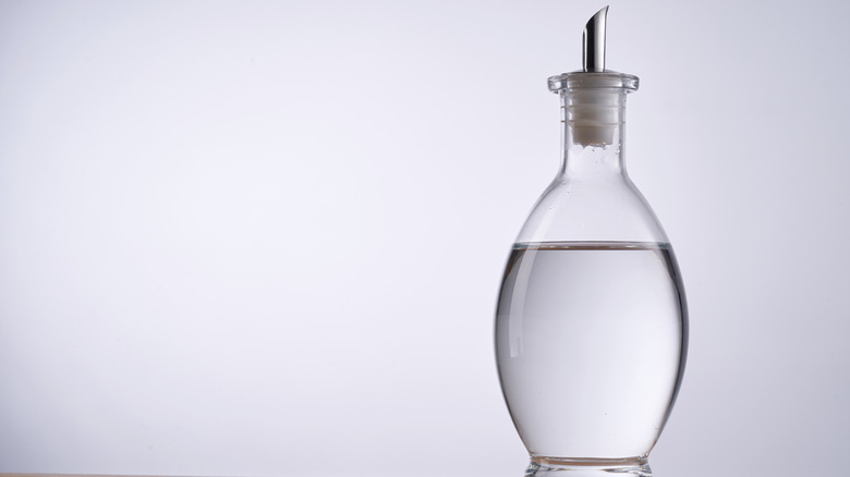 A clear bottle of white vinegar.