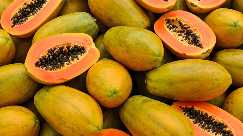 whole and halved papaya fruits