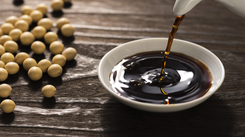 Soy sauce being poured into a white saucer