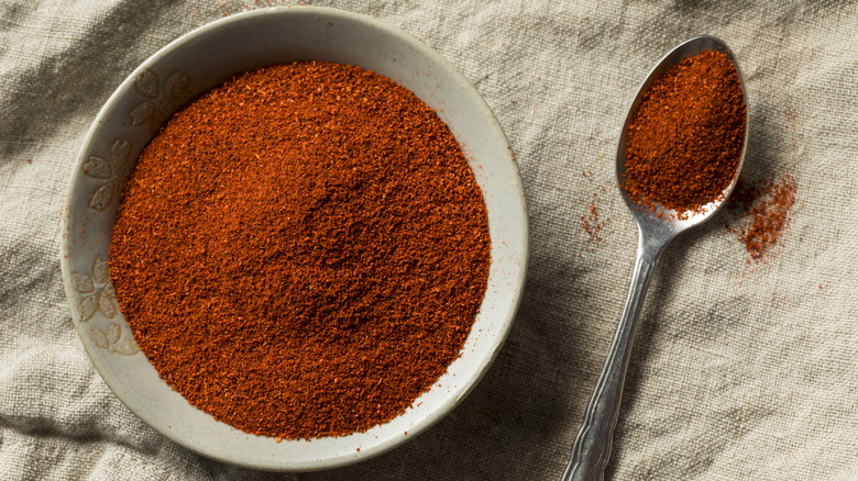 Smoked paprika in a ceramic bowl and on a metal spoon