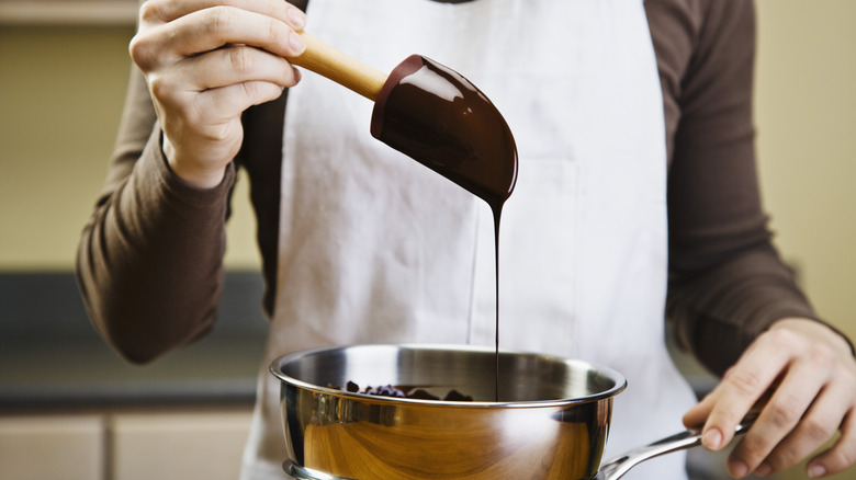Chocolate falls off a spoon into a bowl