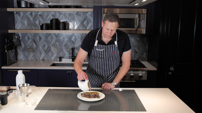 Pat LaFrieda pouring gravy onto meat 