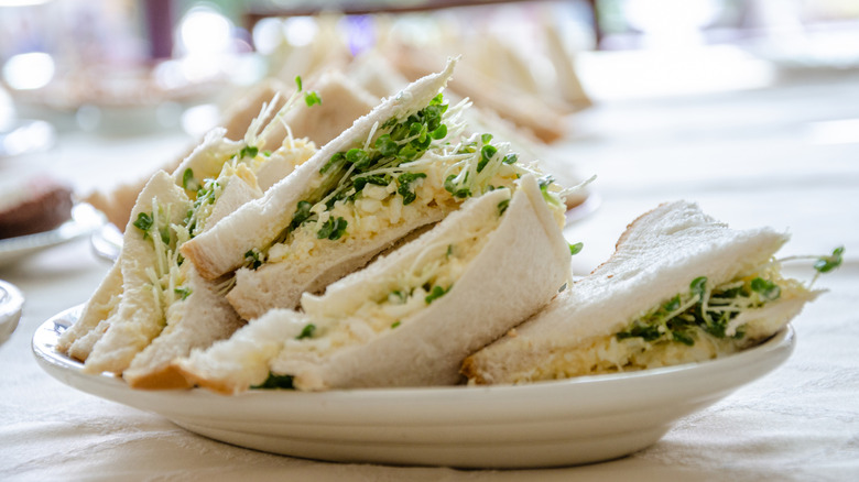 a plate of egg and cress sandwiches on a table