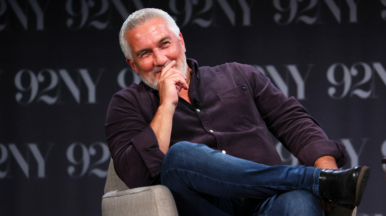 Paul Hollywood sitting and laughing on stage