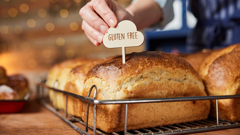 Photo of a baker adding a gluten free sign onto the bread