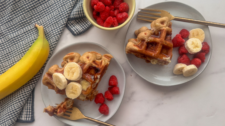 Waffles on plates served with fruit