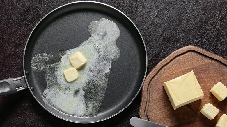 Butter melting in a frying pan next to solid butter.