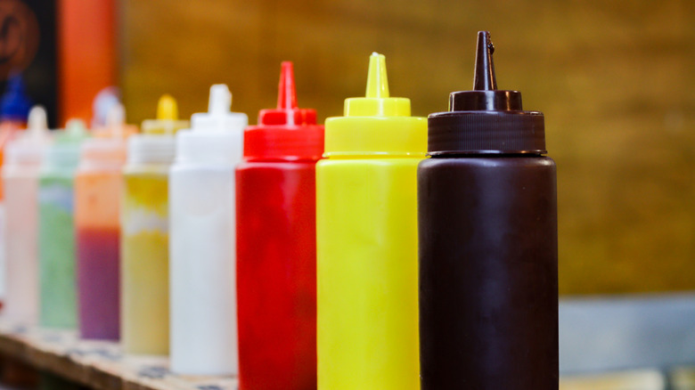 Condiment squeeze bottles in a row.