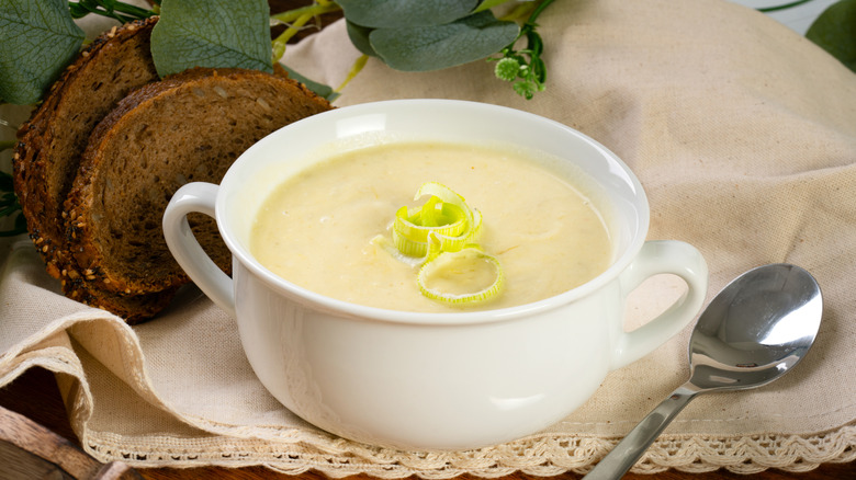 Bowl of potato soup with a spoon on the side