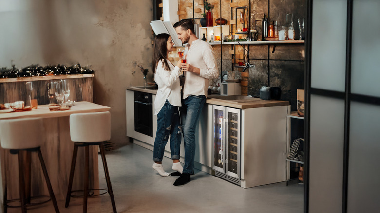 Couple standing next to Yeego's French door wine and beverage fridge in a kitchen