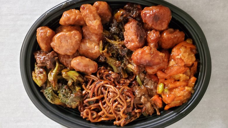 an assortment of prepared P.F. Chang's Home Menu frozen dishes on a black oval serving plate