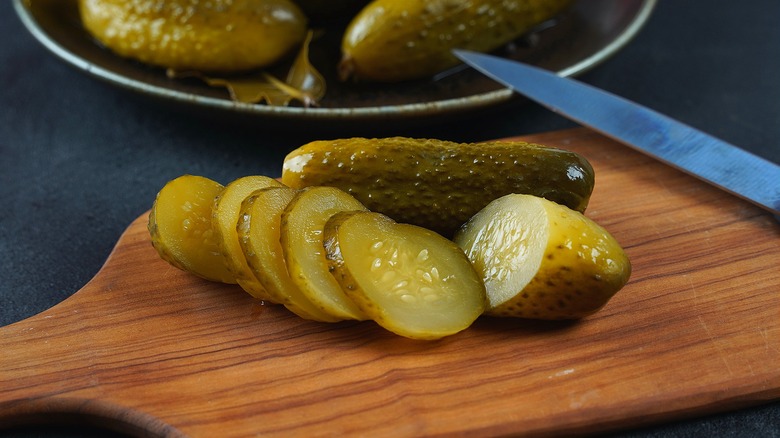 Sliced pickles on a wood cutting board