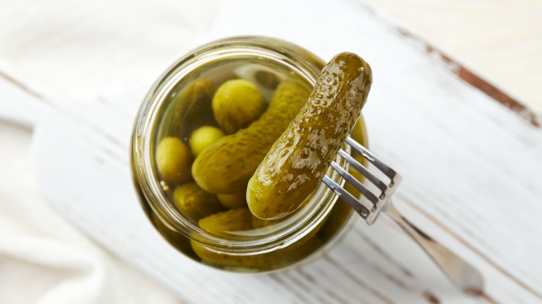 Pickles in a jar on a light wooden background