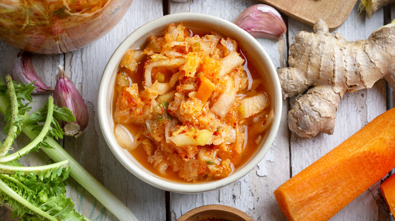 Kimchi in a bowl with ingredients around it