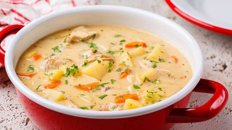 Creamy chicken stew in a red pot with handles