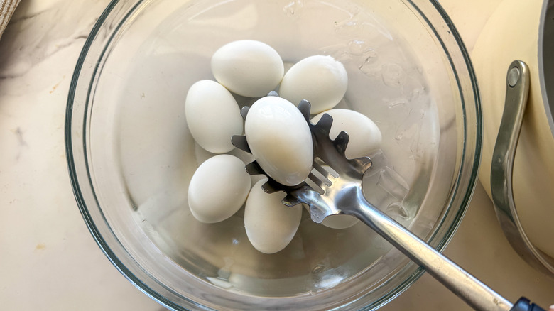 slotted spoon placing egg into ice bath