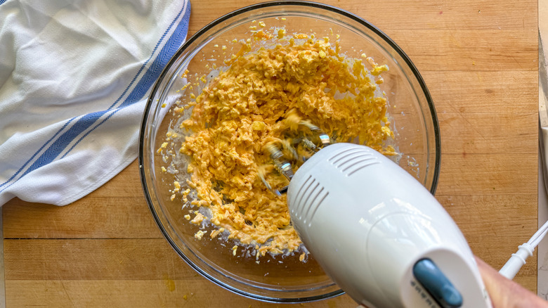 hand mixer beating deviled egg filling in bowl
