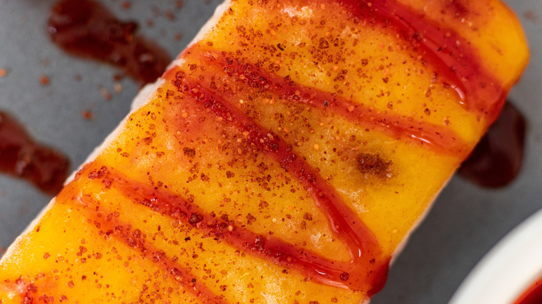 Pineapple spear slathered with chamoy and Tajín