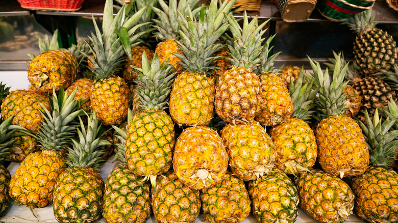 Pineapples stacked on top of each other on a street stand