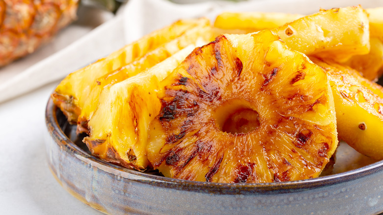 Grilled, caramelized pineapple slices in a bowl