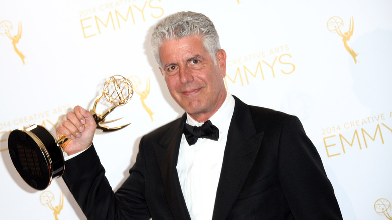 Anthony Bourdain holding an emmy