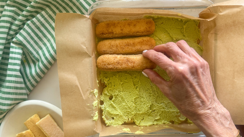 hand adding more ladyfingers