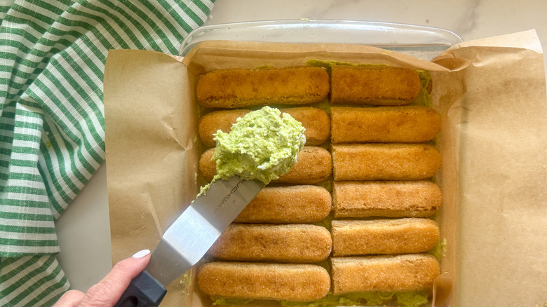 hand spreading layer of cream