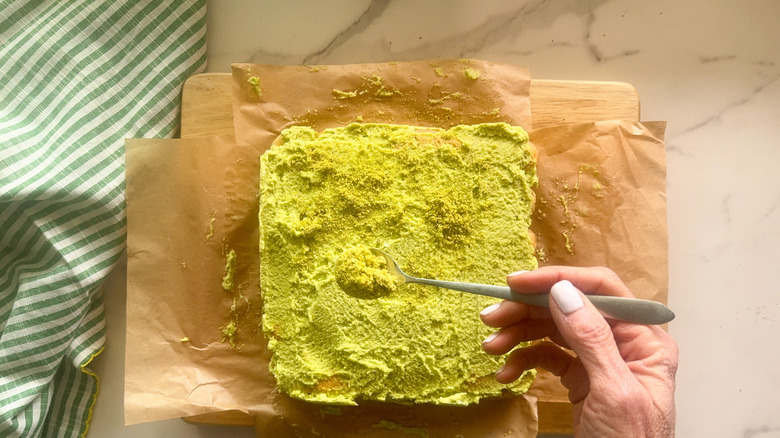 hand adding pistachio powder