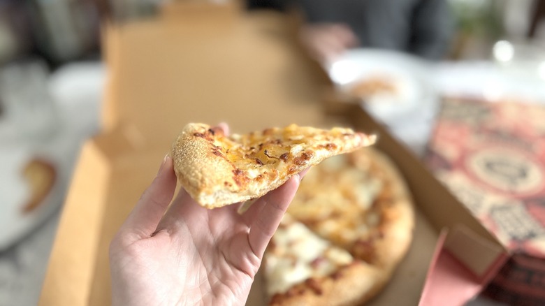 hand holding Pizza Hut hand tossed crust