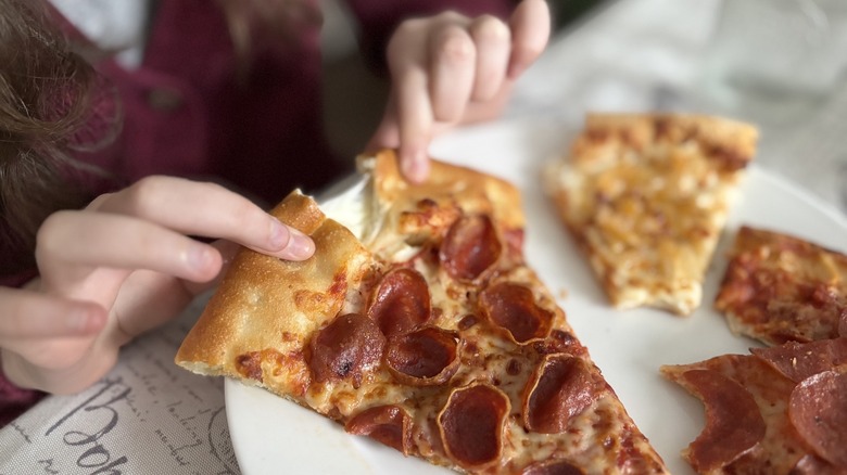 child's hands pulling Pizza Hut stuffed crust apart
