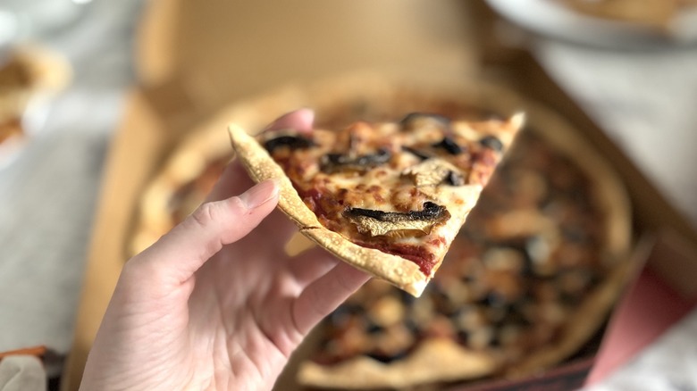 hand holding Pizza Hut thin N crispy crust