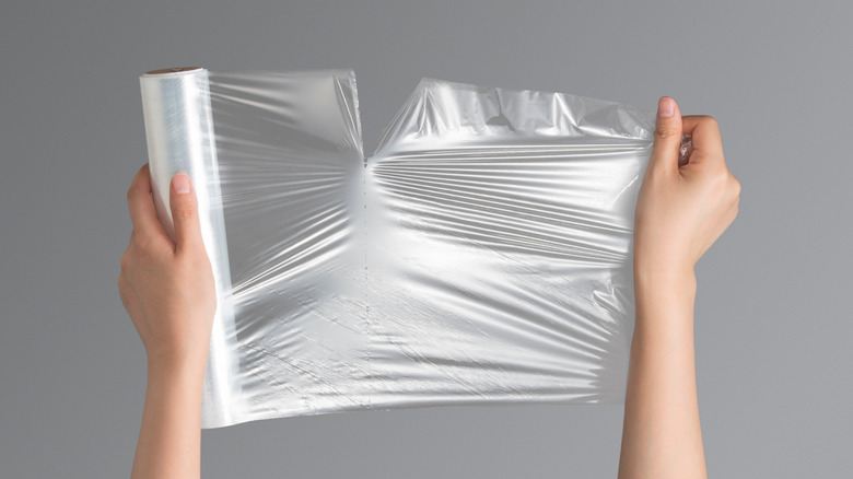 person tearing plastic wrap