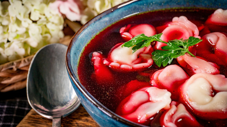Clear Polish beet soup in a bowl with dumplings.
