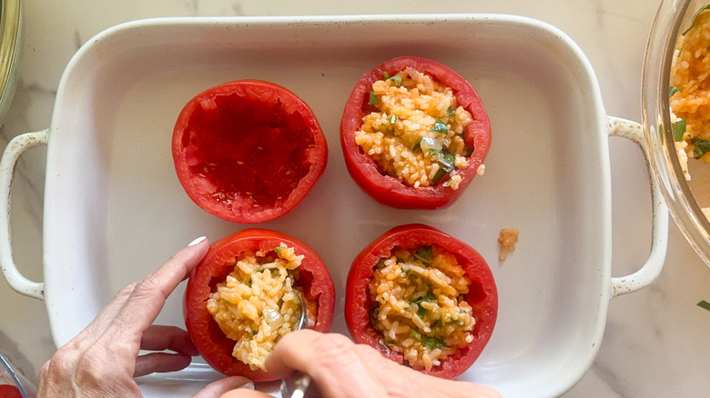 hand stuffing tomatoes