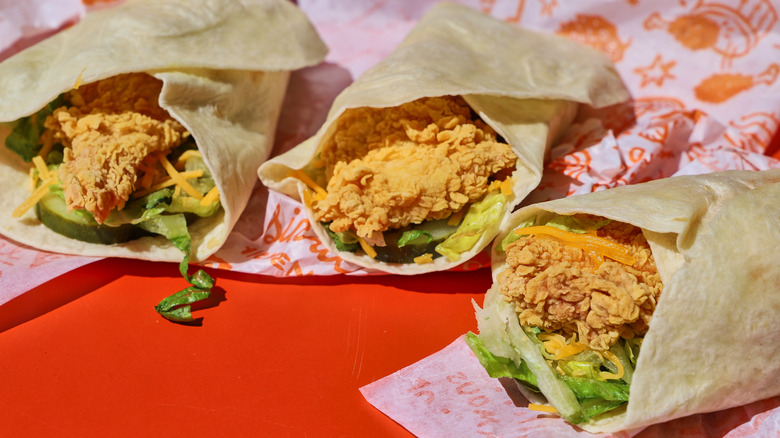 Three fried chicken wraps on a table